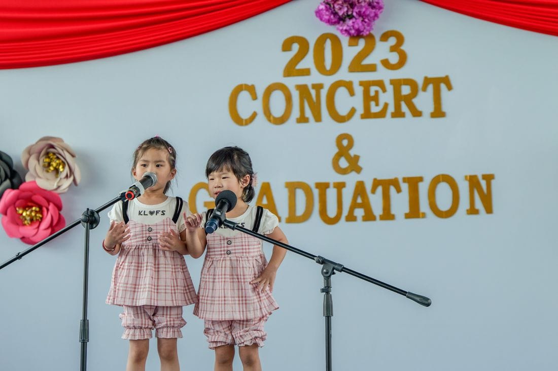 Two children singing at the SunnySeeds concert and graduation