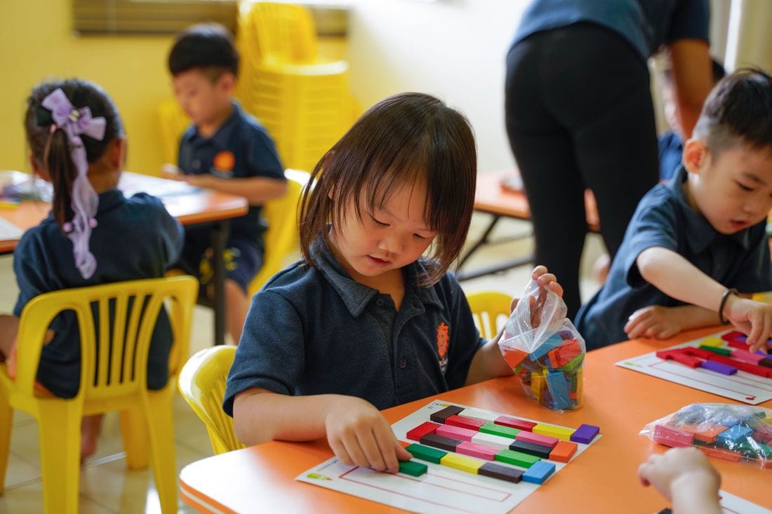 A preschool child sorting coloured number rods